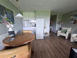 cocina y sala de estar con mesa de madera en una habitación en Bed & Breakfast Boszicht Leeuwarden, en Leeuwarden