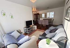 a living room with a couch and a table at Conforto e espaço para família, 3 Quartos, Garagem in Curitiba