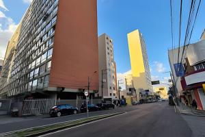 a city street with cars parked on the side of a building at Conforto e espaço para família, 3 Quartos, Garagem in Curitiba