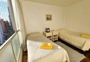 a small room with two beds and a window at Conforto e espaço para família, 3 Quartos, Garagem in Curitiba