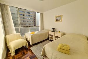 a hotel room with two beds and a window at Conforto e espaço para família, 3 Quartos, Garagem in Curitiba +15 photos