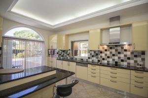 Una cocina grande con gabinetes blancos y una ventana. en Villa Hera, en Vilamoura