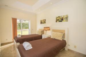 Un dormitorio con dos camas y una ventana. en Villa Hera, en Vilamoura 39 fotos más