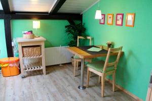 a table and chairs in a room with a green wall at Ferienwohnung Carstensen Nr2 in Fehmarn