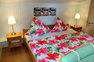 una camera con letto e fiori rossi e rosa di Ferienwohnung Carstensen Nr2 a Fehmarn