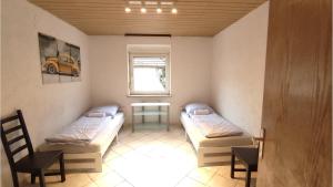 a room with two beds and a table and a window at Neu-Ulm City Monteurwohnung in Neu Ulm