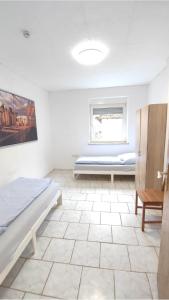 a bedroom with a bed and a bench in a room at Neu-Ulm City Monteurwohnung in Neu Ulm +4 photos