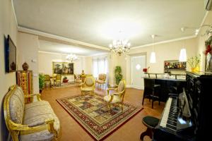 - un salon doté de meubles et d'un piano dans l'établissement Boutique Hotel L'Imperatrice, à Foiano della Chiana