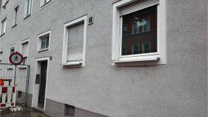 a building with two windows and a clock in a window at Neu-Ulm City Monteurwohnung in Neu Ulm