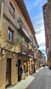 Eine Frau steht vor einem Gebäude auf einer Straße. in der Unterkunft Legado de Ugarte, Casa Rural in Laguardia