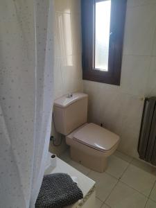 a small bathroom with a toilet and a window at Casa Marco in Gistaín +25 photos