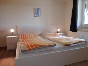 a bed with two pillows on it in a bedroom at "Höper Mittelhof" Ferienhaus Nr3 in Lemkendorf