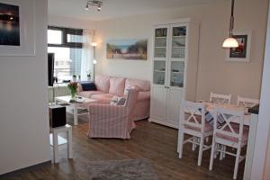 a living room with a pink couch and a table at Meeresrauschen in Staberdorf