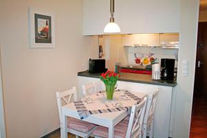 a kitchen with a table with a vase of flowers on it at Meeresrauschen in Staberdorf