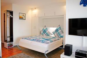 a small bedroom with a bed with a tv at Meeresrauschen in Staberdorf +7 photos