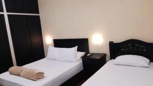a bedroom with two beds with white sheets at HOTEL CASA VANIA MOMPOX, Centro histórico, Con Parqueadero en el Hotel in Mompos
