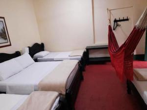 a room with four beds and a hammock in it at HOTEL CASA VANIA MOMPOX, Centro histórico, Con Parqueadero en el Hotel in Mompos +10 photos