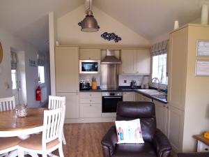 Una cocina con una mesa, un sofá y una silla. en Bungalow - Beaurepaire Beach House, en Filey