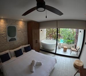 a bedroom with a large bed and a bath tub at Jade Tulum Zen Residences 22 in Tulum +10 photos