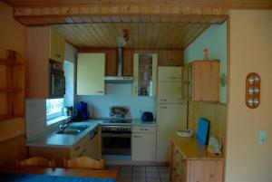 a kitchen with white appliances and wooden cabinets at Ferienwohnung Cantay - Nr 2 in Fehmarn
