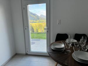 a dining room with a table and a glass door at Appartement Niesenblick 1 in Spiez