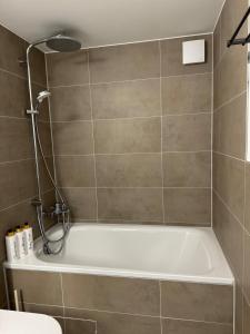 a bathroom with a bath tub and a toilet at Appartement Niesenblick 1 in Spiez +27 photos