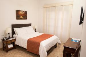 a bedroom with a bed and a table and a window at Hotel La Plazuela in Popayan +31 photos