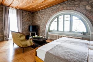 ein Schlafzimmer mit einem Bett, einem Stuhl und einem Fenster in der Unterkunft Hotel Acacia in Marly-le-Grand