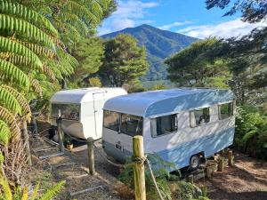 ein Wohnmobil und ein Wohnmobil neben einander geparkt in der Unterkunft Vintage Caravans by the Sea in Whatanihi