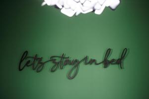 a sign that says let everything improved on a green wall at Уютно Студио Verde Suites 33 in Blagoevgrad