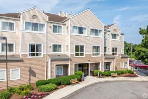 a large apartment building with a parking lot at Avia Residences on Research - Extended Stay in Westborough