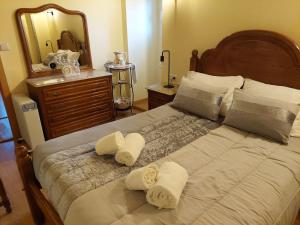 a bedroom with a large bed with towels on it at Cantinho de Tourêm in Tourém