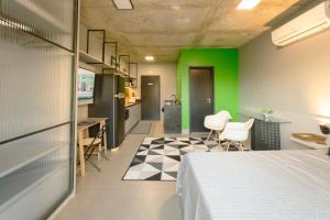a room with a bed and a green wall at Apartamento Centro Moderno CA403 in Maringá