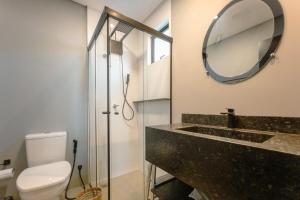 a bathroom with a sink and a mirror and a toilet at Apartamento Centro Moderno CA403 in Maringá +31 photos