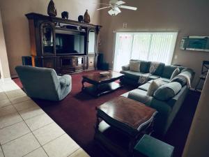 a living room with a couch and chairs and a tv at Beautiful Pool Home near the I95 Exit 284 in Palm Coast