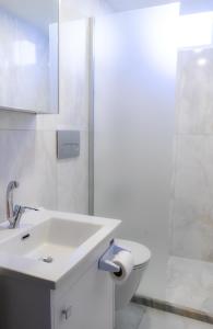 a white bathroom with a sink and a shower at Beyaz Konak 1 Cappadocia in Gülşehir