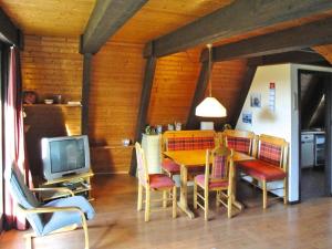 a dining room with a table and chairs and a television at Ferienhaus, Burhave in Burhave