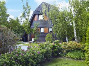 a wooden house with a garden in front of it at Ferienhaus, Burhave in Burhave