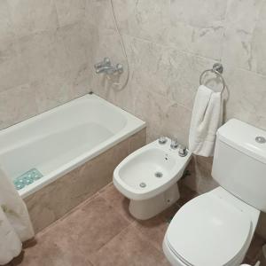 a bathroom with a toilet and a tub and a sink at Cabaña CALLE VIEJA in La Porteña +9 photos