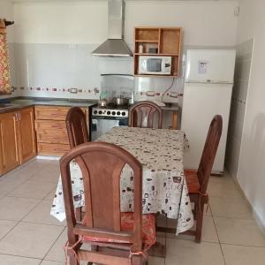 a kitchen with a table and chairs and a refrigerator at Cabaña CALLE VIEJA in La Porteña