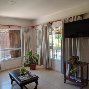 a living room with a tv and some windows at Cabaña CALLE VIEJA in La Porteña