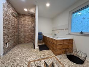 a bathroom with a tub and a large window at Ferienhaus Rehblick Schwerin in Schwerin +21 photos