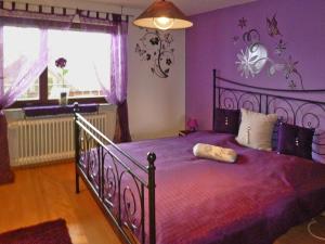 a bedroom with a large bed with purple walls at Apartment in Langenargen near Lake Constance in Oberdorf