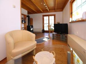 a living room with a chair and a television at Ferienhaus , Tanne in Tanne