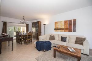a living room with a white couch and a table at Casa Oliveira in Loulé