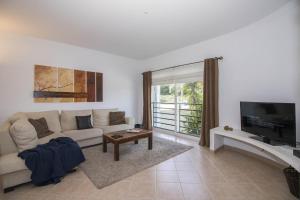 a living room with a couch and a tv at Casa Oliveira in Loulé