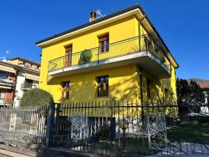 a yellow house with a balcony on top of it at Simona Francshouse in Gavirate