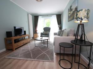 a living room with a couch and a tv at Ferienwohnung Haus am Berg, Lonau in Lonau