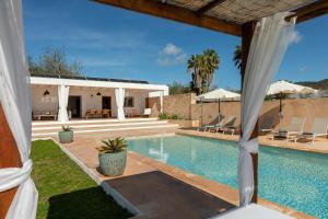 a villa with a swimming pool and a house at New! Villa Can Vinyes in San Antonio