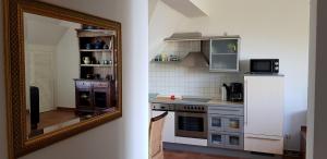 una cucina con specchio e frigorifero bianco di Ostseekieker a Wustrow Altre 17 foto